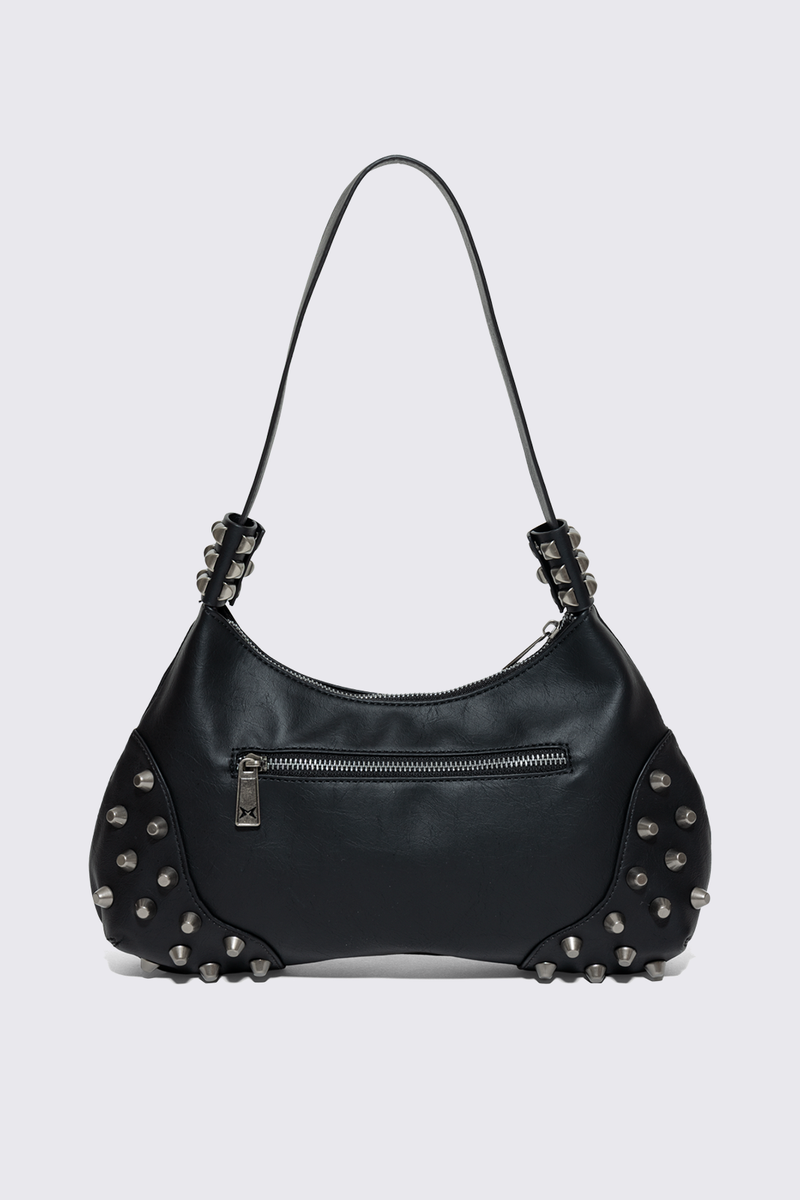 Black faux leather shoulder bag with white sinner cross print, studded panels and grunge aesthetic.