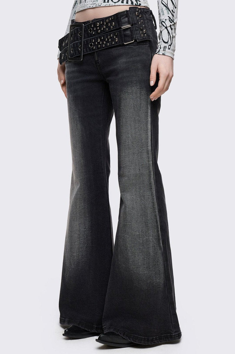 Grey washed flared jeans with double-buckle belt.