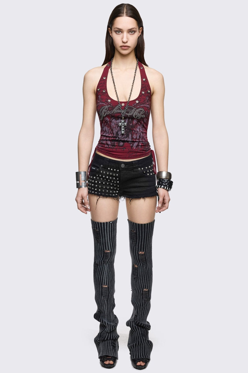 Black denim hot pants with silver spikes, raw frayed hems and low-rise fit in a grunge Y2K style.