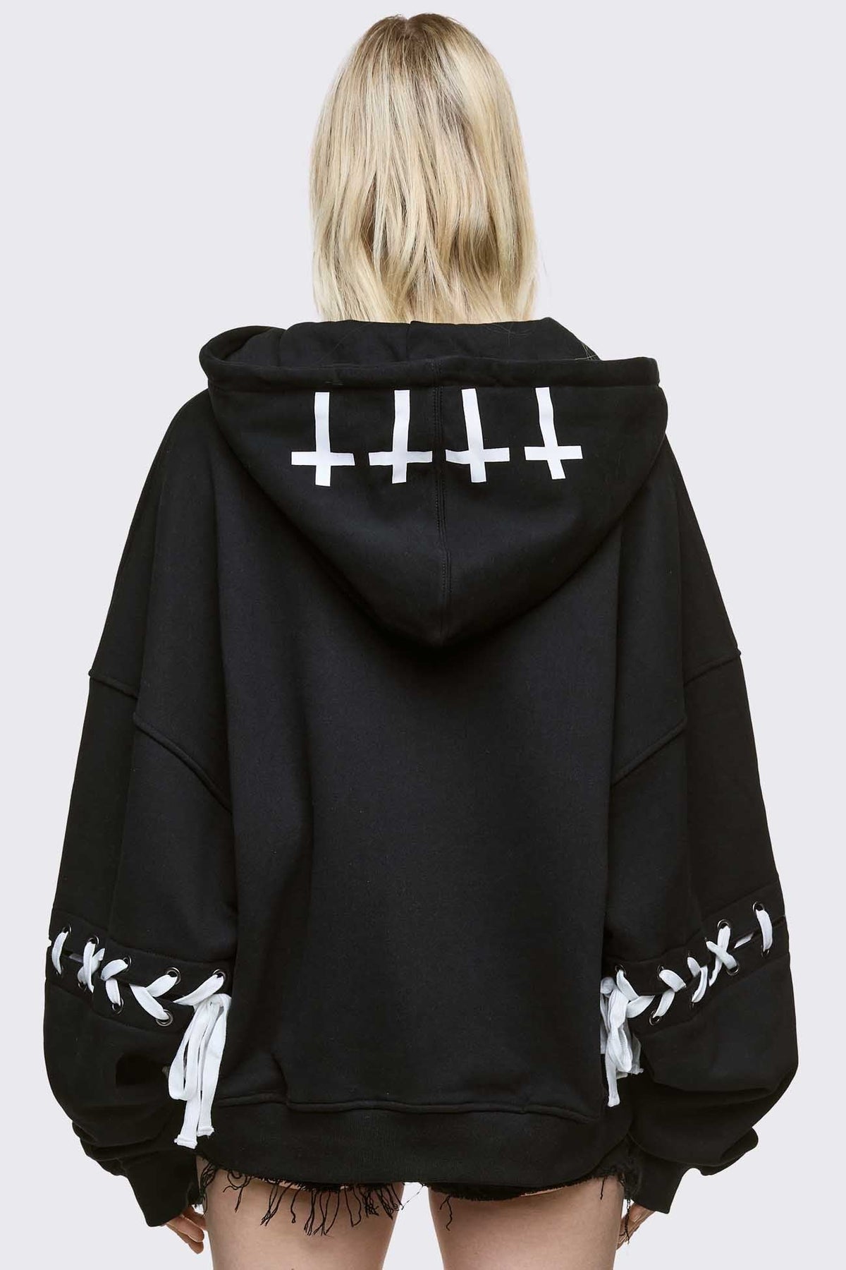 Black zip up hoodie jacket with "Every angels terrifying" graphic print and white lace-up details.