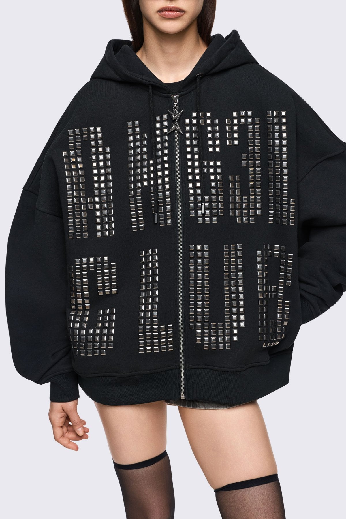 Black cotton zip-up hoodie with studded Angel Club design, oversized fit and grunge streetwear vibe.