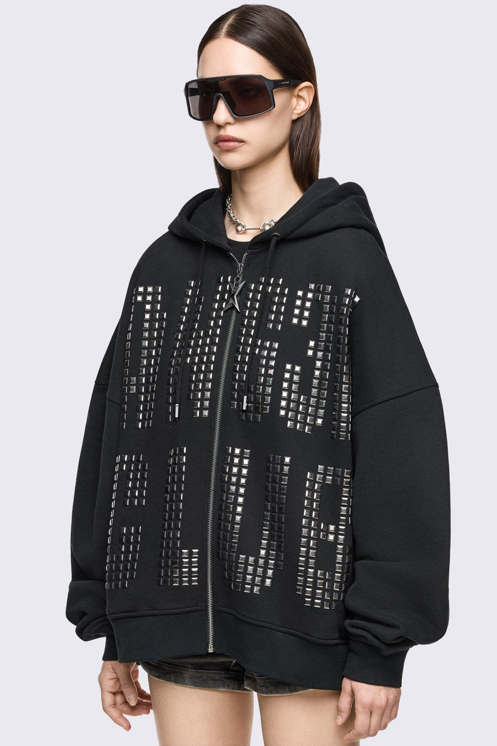 Black cotton zip-up hoodie with studded Angel Club design, oversized fit and grunge streetwear vibe.