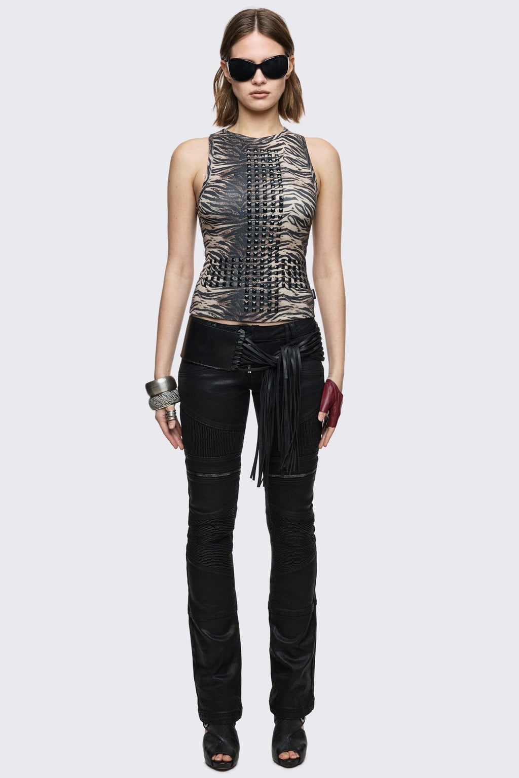 Bootcut jeans in black coated denim with ribbed paneling and zipper details, low-rise grunge aesthetic.