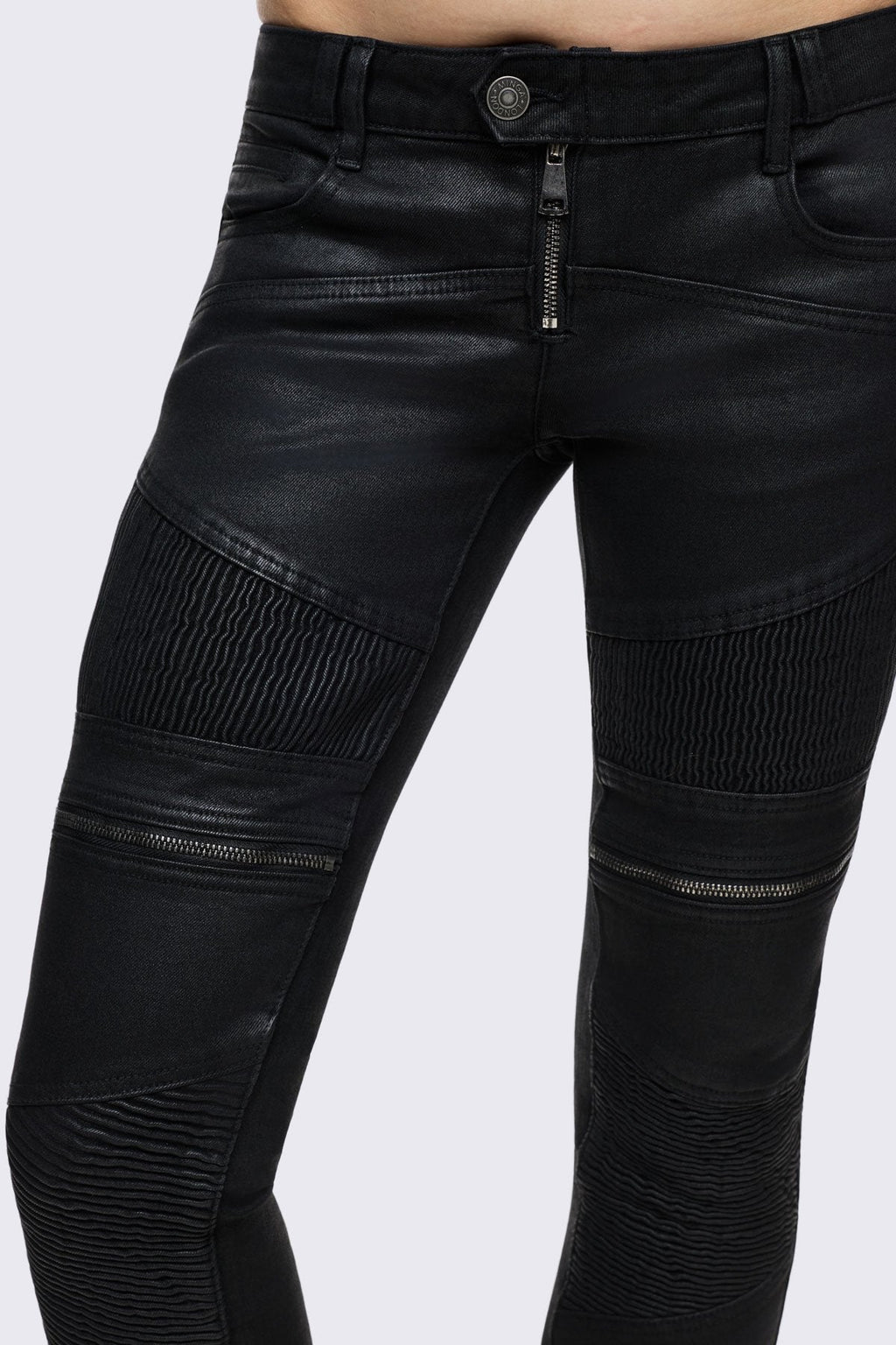 Bootcut jeans in black coated denim with ribbed paneling and zipper details, low-rise grunge aesthetic.