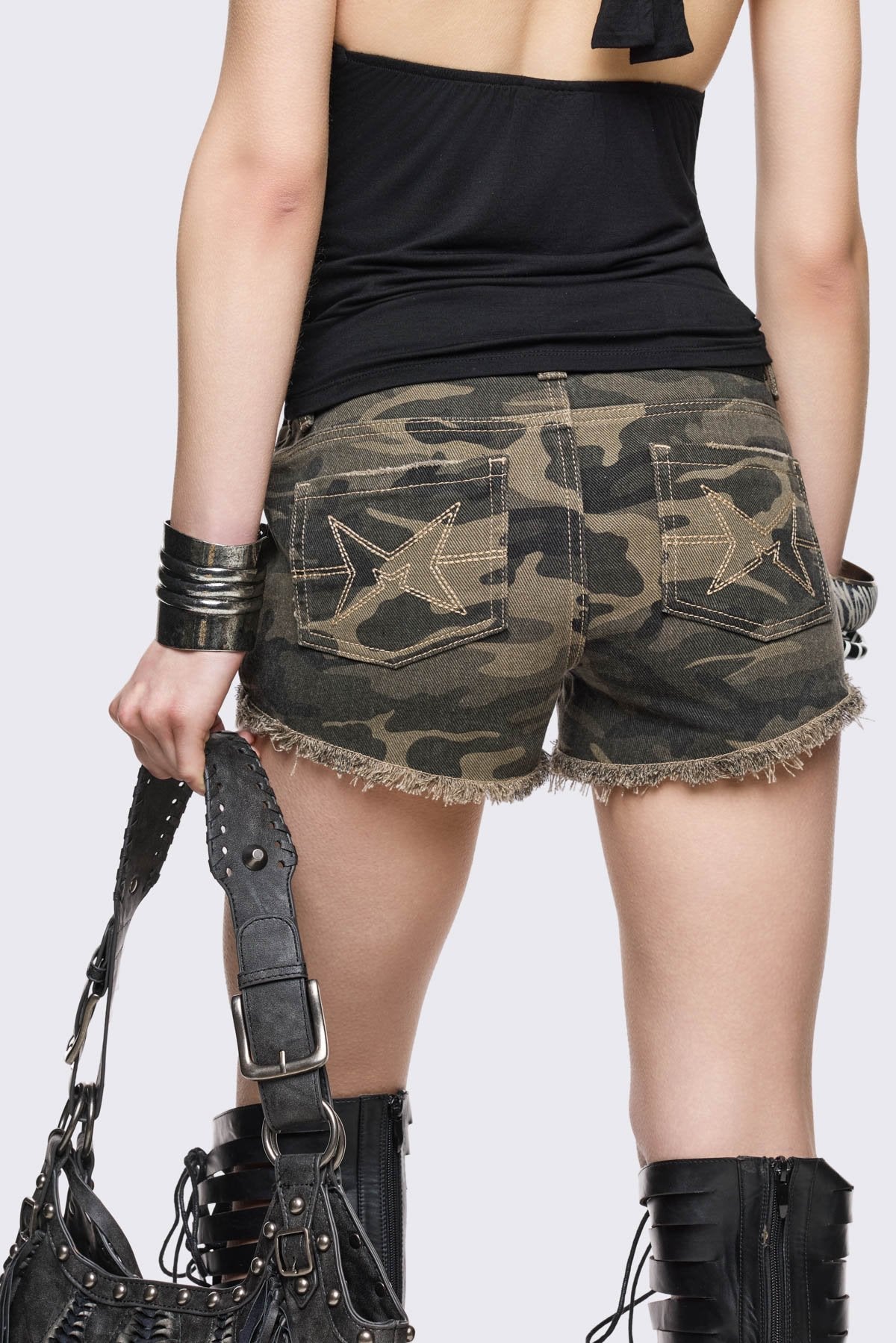 Camo micro shorts in stretch cotton with shredded details, exposed pockets, silver studs and raw hems, grunge vibe.