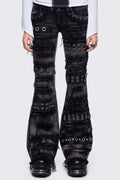 Black washed flare jeans featuring heavy distressed and shedded, eyelet, piercing and stud details. 