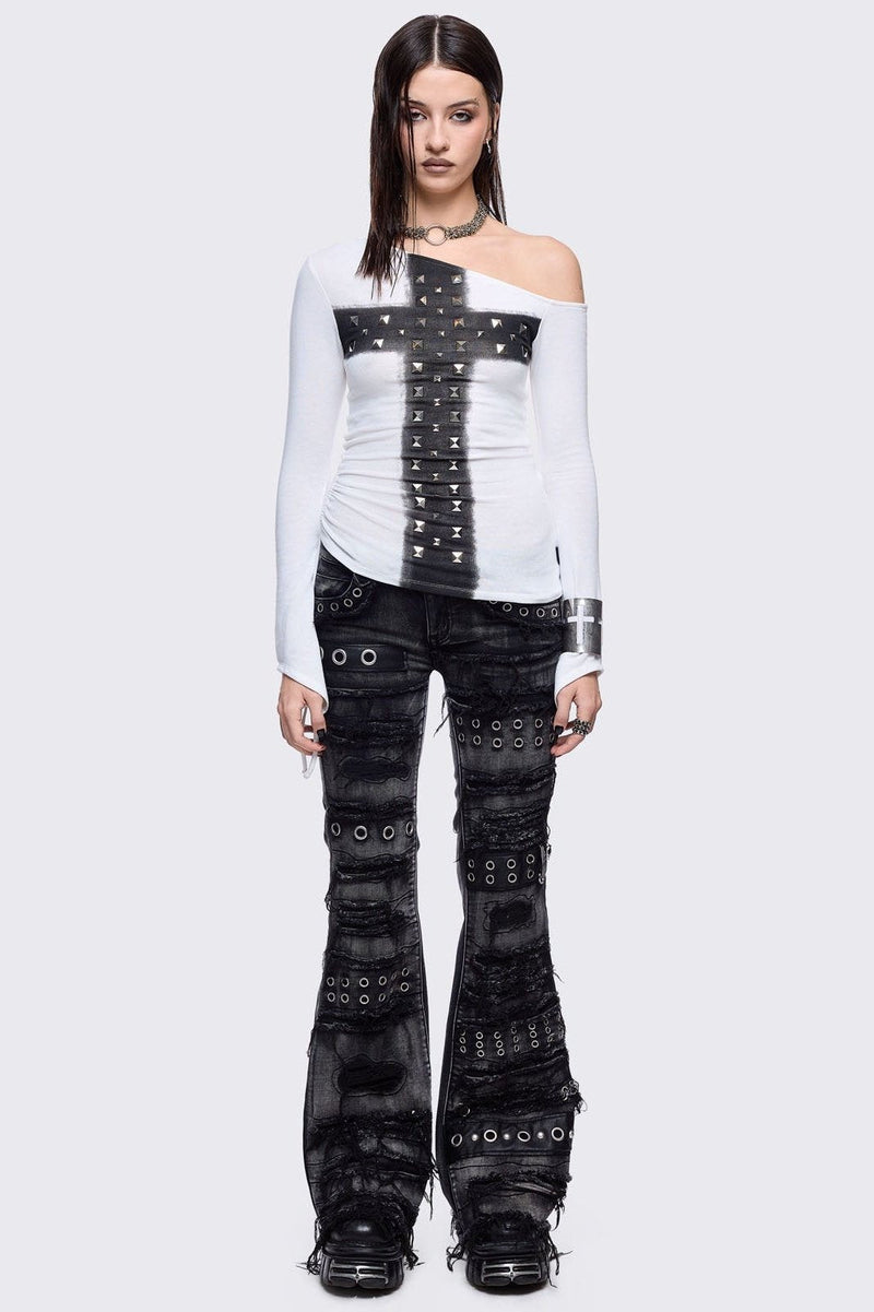 Black washed flare jeans featuring heavy distressed and shedded, eyelet, piercing and stud details. 