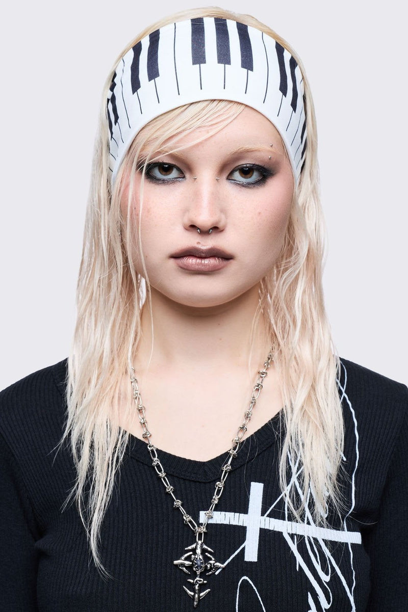 White wide headband with piano graphic print. 