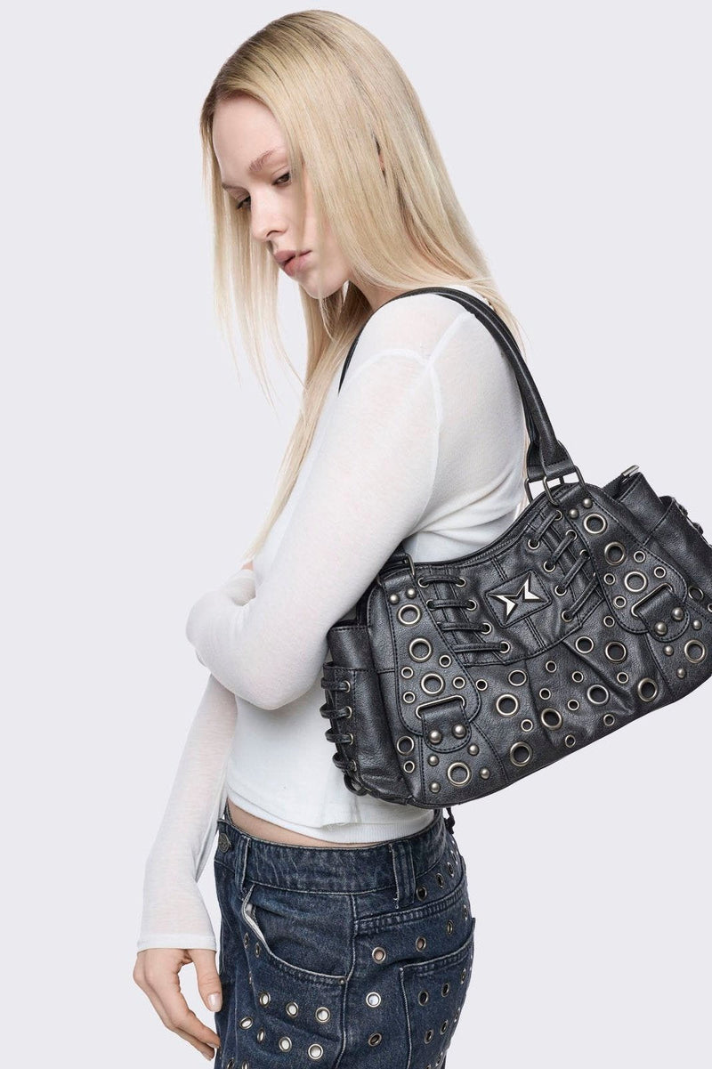 Black vegan leather shoulder bag with silver eyelets and multiple pockets