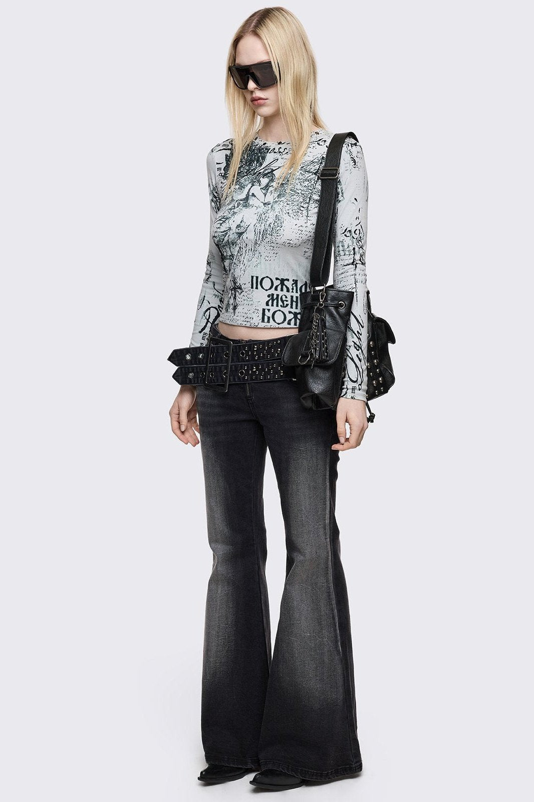 Grey washed flared jeans with double-buckle belt. 