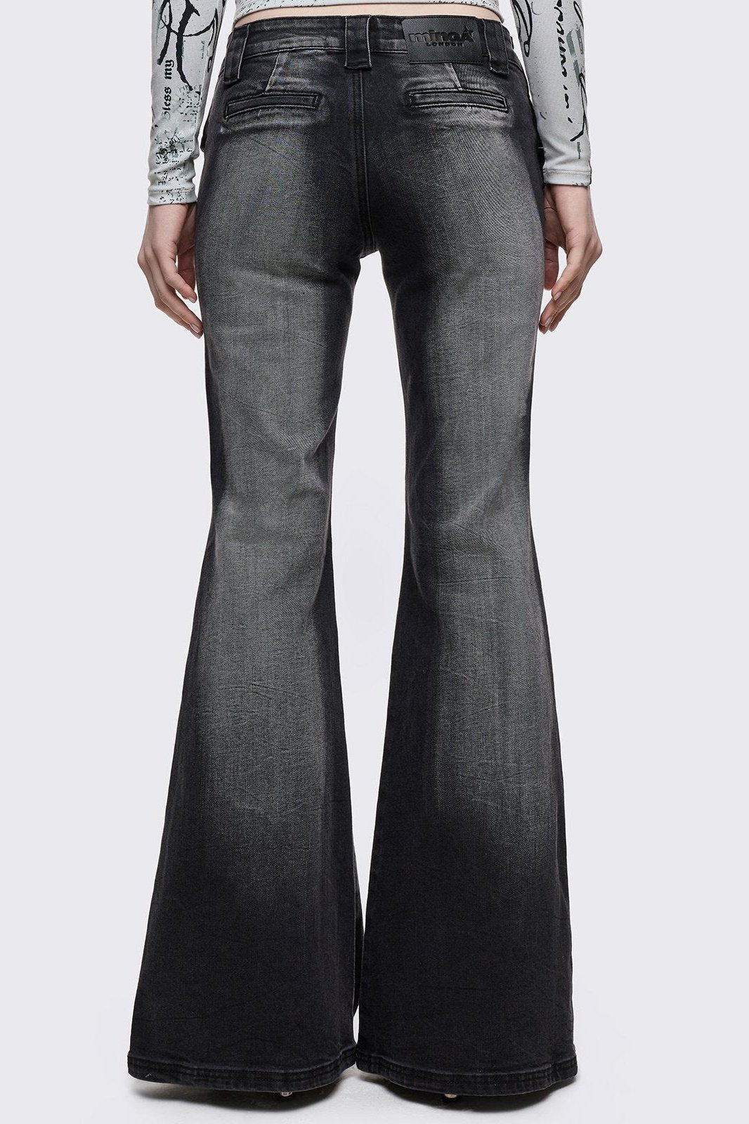 Grey washed flared jeans with double-buckle belt. 