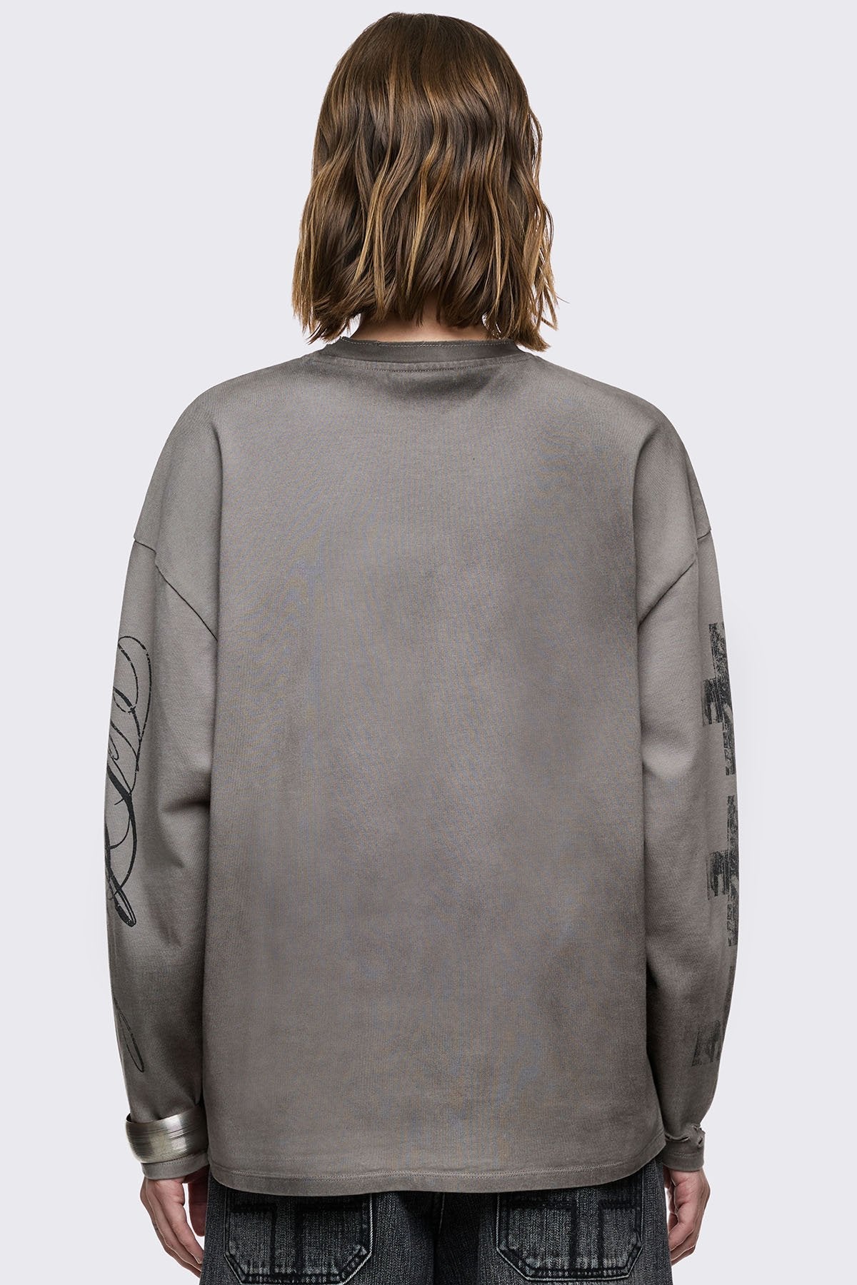 Grey cotton long sleeve T-shirt with cross graphic, studs and distressed hem in a grunge goth style.