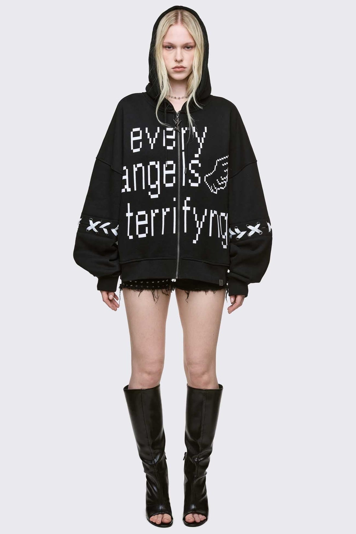 Black zip up hoodie jacket with "Every angels terrifying" graphic print and white lace-up details.