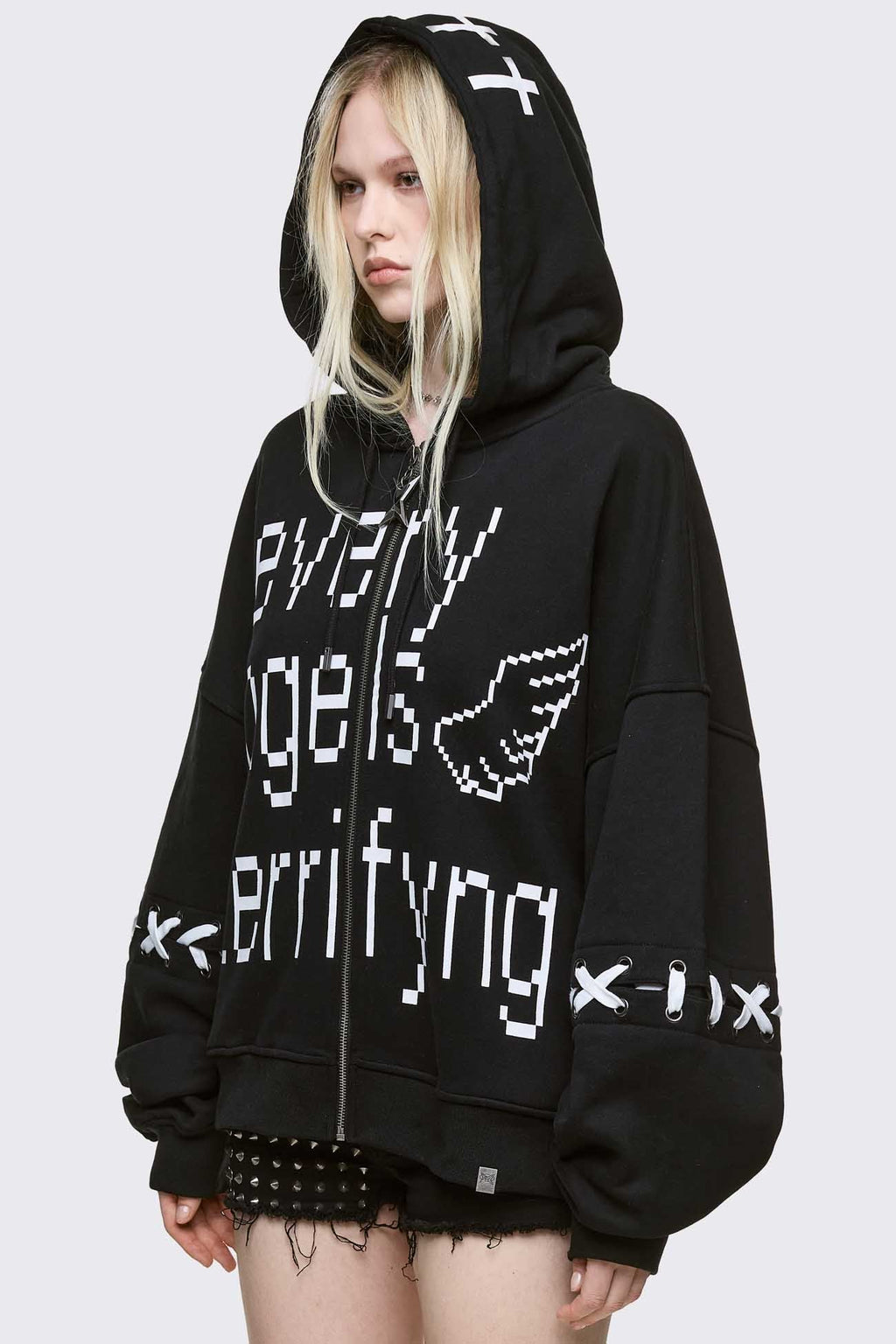 Black zip up hoodie jacket with "Every angels terrifying" graphic print and white lace-up details.