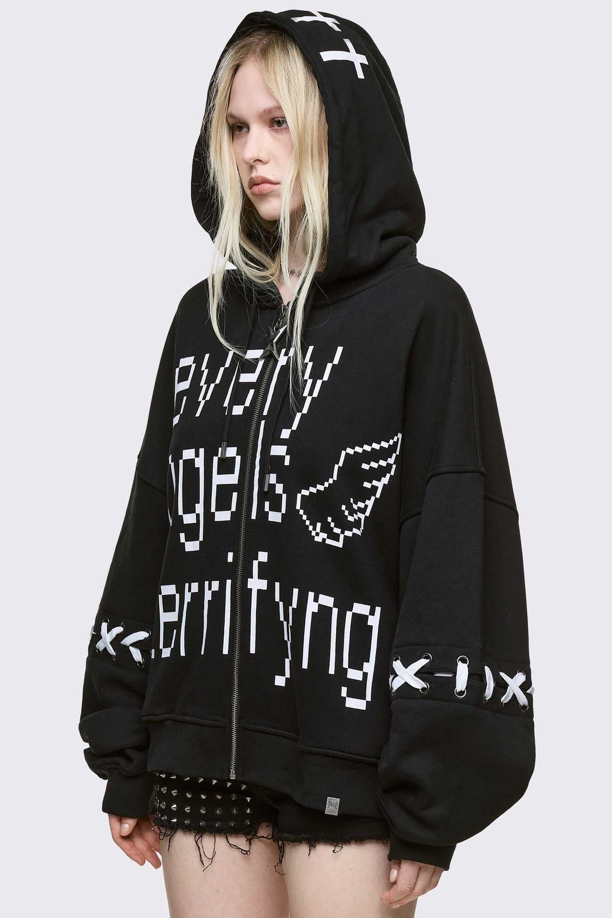 Black zip up hoodie jacket with "Every angels terrifying" graphic print and white lace-up details.
